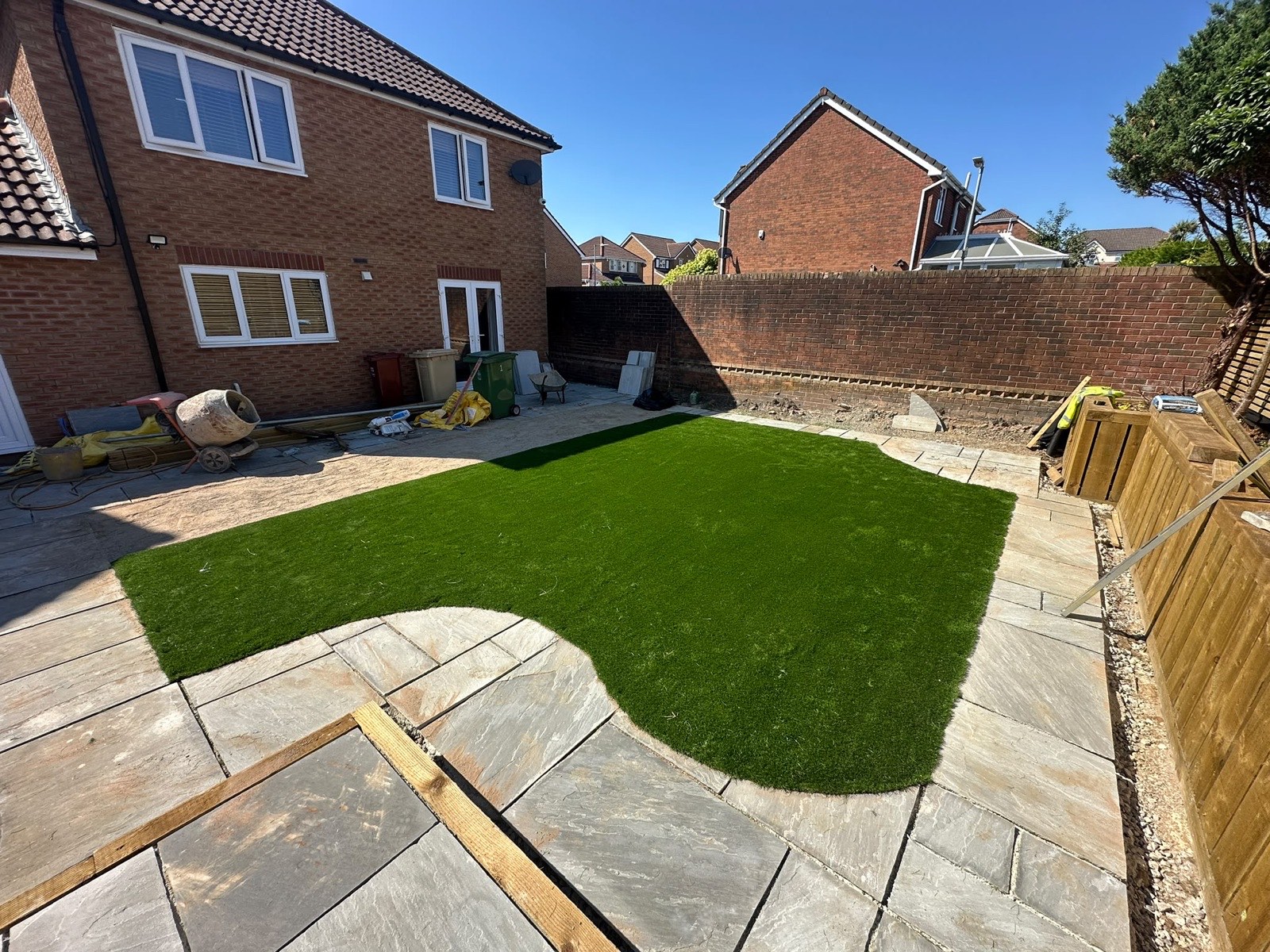 Finished garden with Indian stone patio, lawn and timber fencing