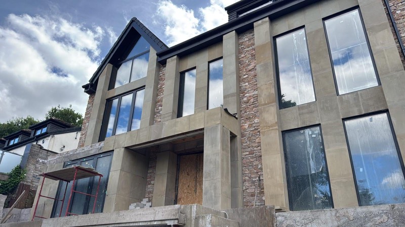 Front elevation of a new build with stone cladding and large glazing